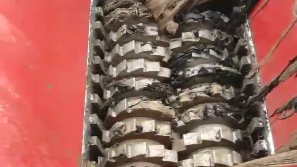 Intermeshing cutter shafts gripping fibrous material inside a red shredder chamber