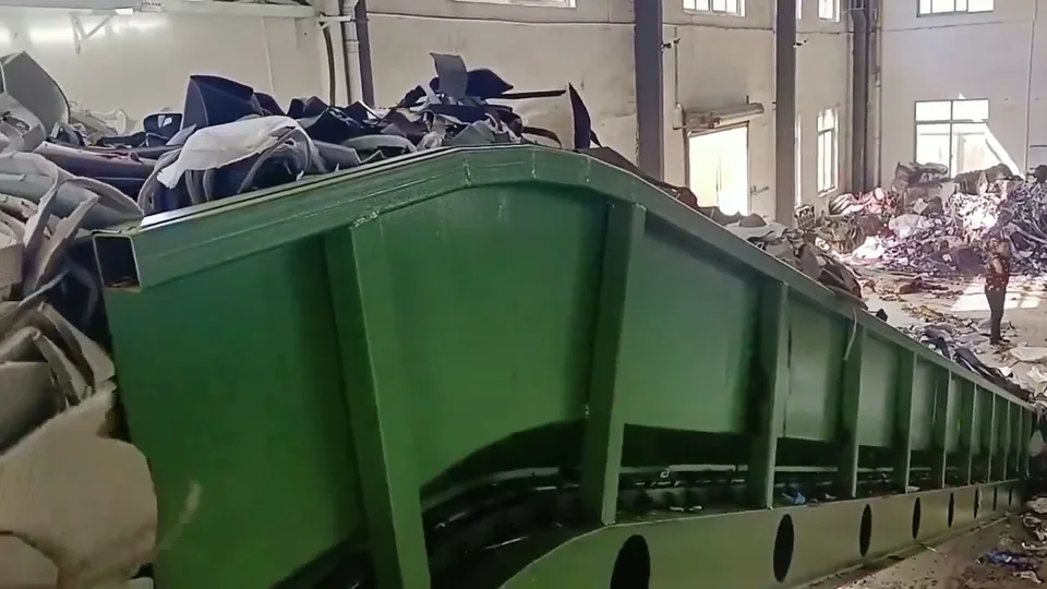 Bulky mixed material in a green feed hopper inside a treatment building