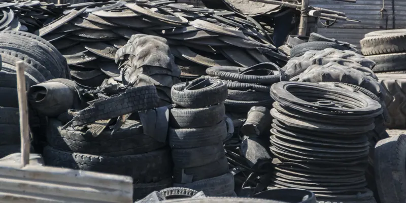 Industrial tires and reinforced rubber tire materials for shredding
